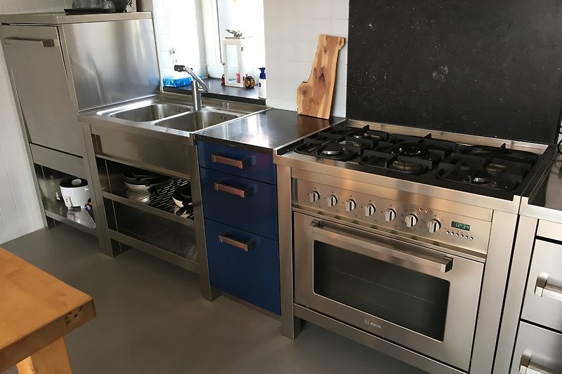 Moderne roestvrijstalen keuken met elektrische oven, vijf-branderkachel, vaatwasser en koel-diepvriezer