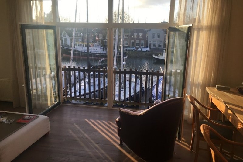 Ruime woonkamer met een prachtig uitzicht op de Oosterhaven en het historische centrum van Enkhuizen.