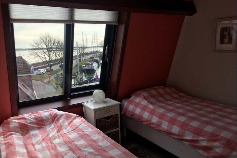 Tweede slaapkamer twee eenpersoonsbedden en uitzicht over het IJsselmeer
