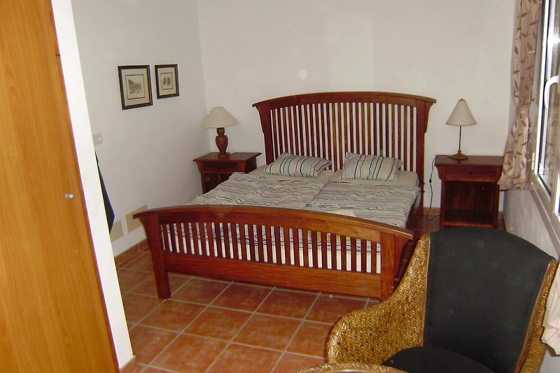 Stilvolles Schlafzimmer (3) mit Holzmöbeln und gemütlichem Bett.