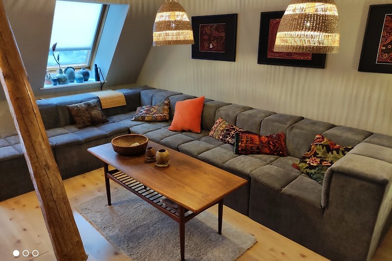 Gemütliches Wohnzimmer mit Holzmöbeln, und großer Couch, Fernseher und Wlan