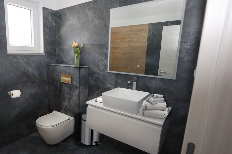 Modernes Badezimmer mit lila Akzenten und Holzdetails.