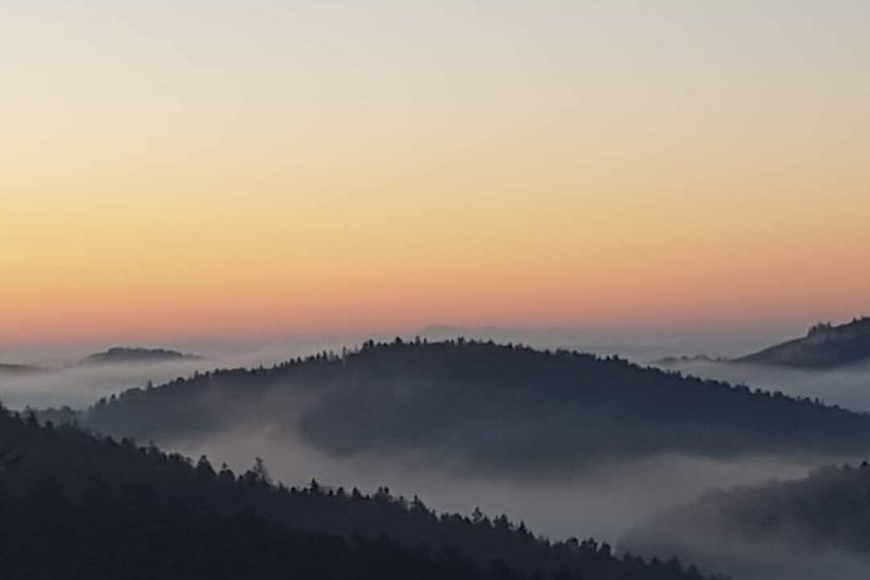 Malerische Landschaft mit Nebel und Sonnenaufgang.