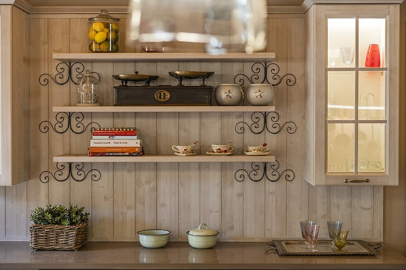 Una cucina luminosa con mobili in legno, piano in marmo e finestra panoramica.