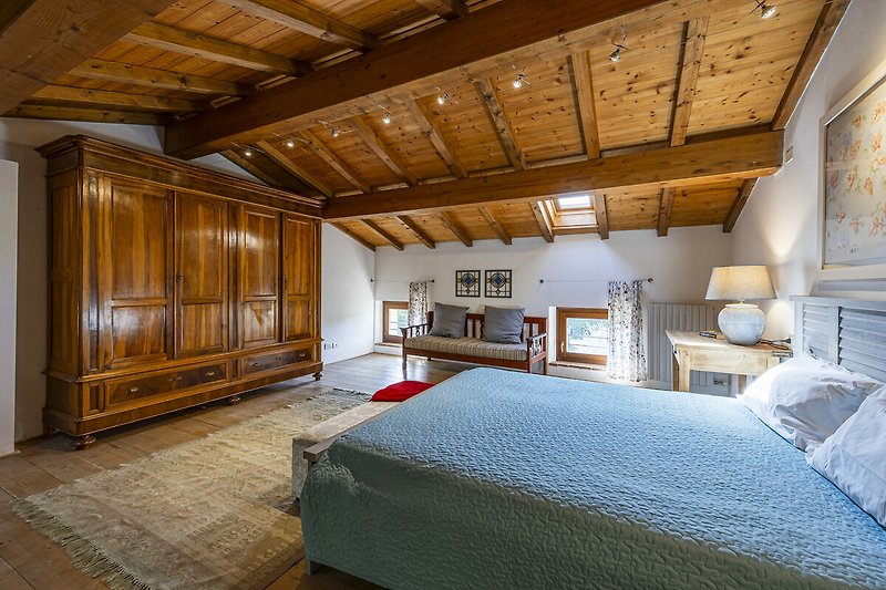 Una stanza confortevole con mobili in legno e un letto accogliente.