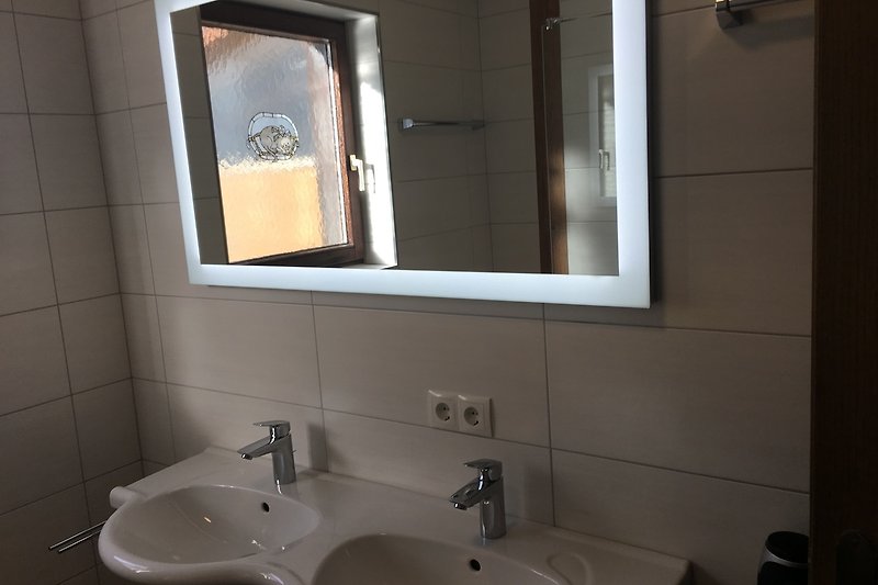 Willkommen in diesem stilvollen Badezimmer mit elegantem Spiegel, braunem Waschbecken und modernen Armaturen. Entspannen Sie sich und erfrischen Sie sich hier!