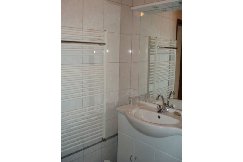 Schönes Badezimmer mit Spiegel, Waschbecken und Dusche.