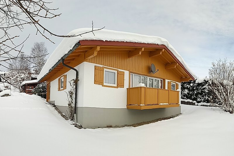 Ferienhaus in winterlicher Landschaft und verschneiten Bäumen. Perfekt für einen erholsamen Urlaub.