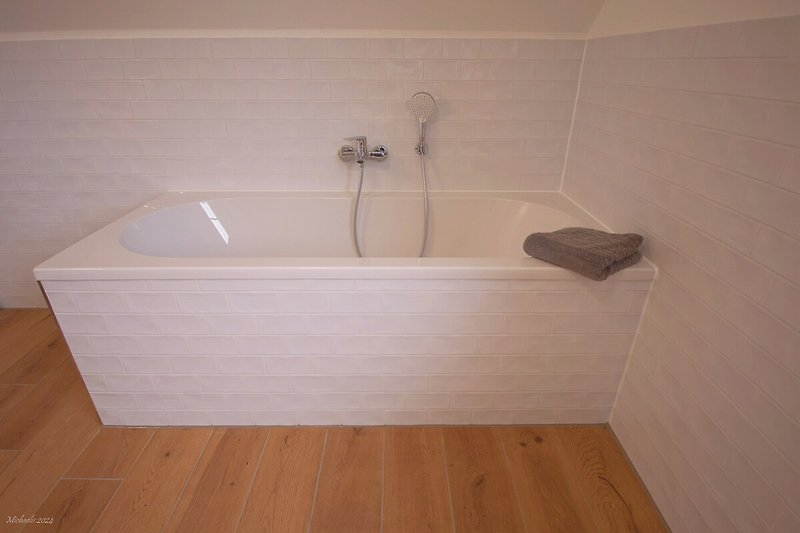 Badewanne in rechteckigem Holzbadezimmer.