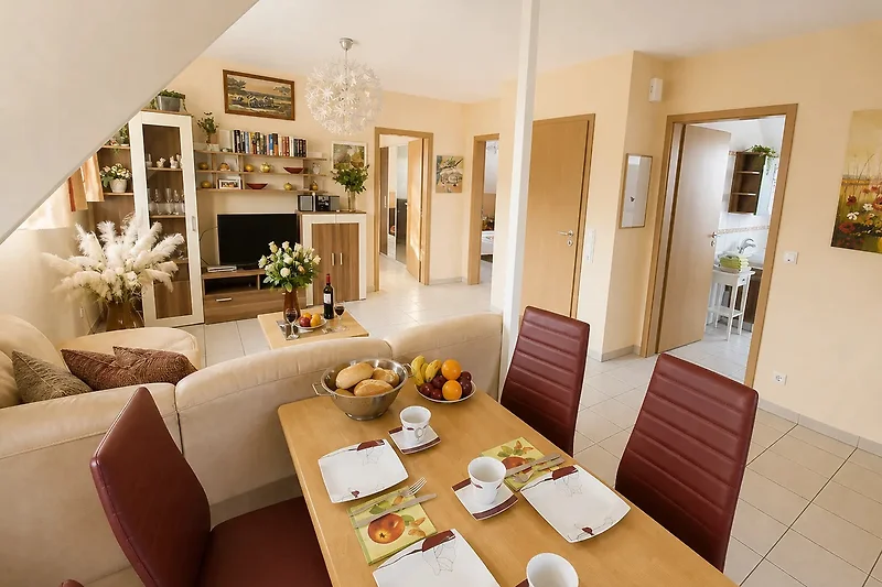 Großzügige Suite mit Sofa, Esstisch, Pflanzen und stilvollem Dekor.
