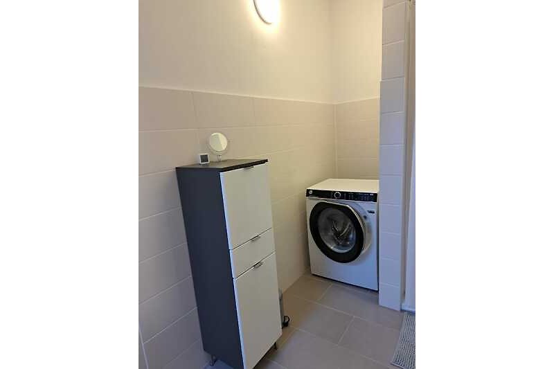Ein modernes Badezimmer mit Waschmaschine.