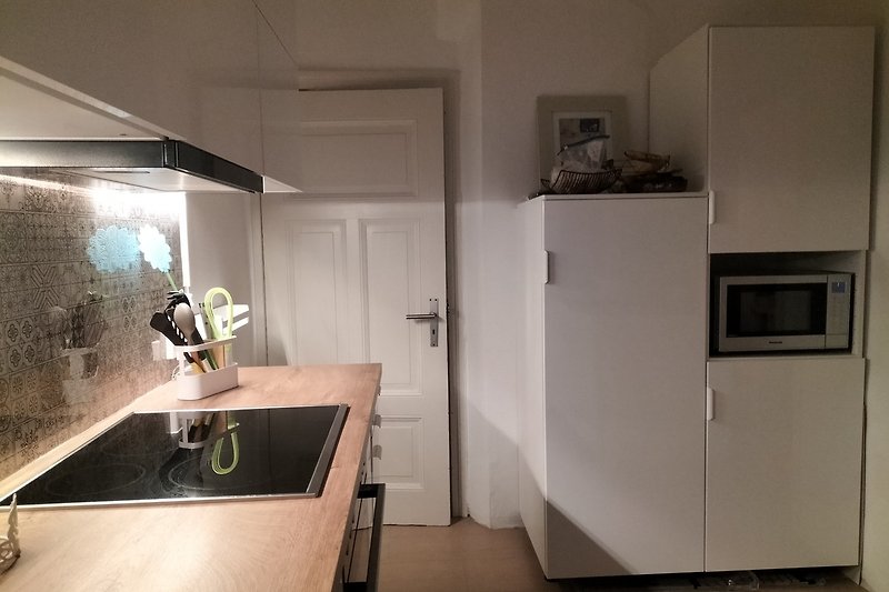 Eine moderne Küche mit stilvoller Einrichtung, Kühlschrank mit Gefrierfach und Kombi-Mikrowelle