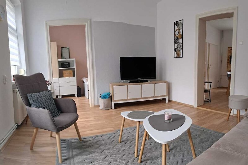 Ein komfortables Wohnzimmer mit stilvollen Möbeln und Holzboden.
