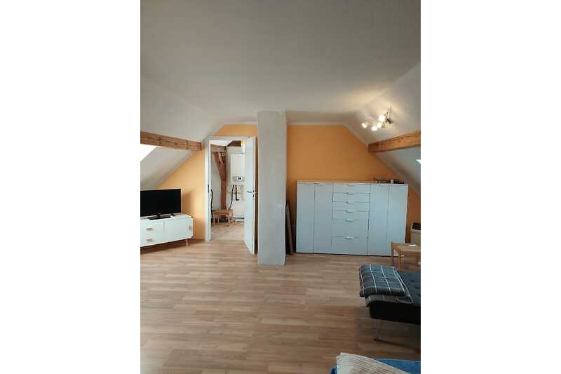 Dachgeschoss mit Holzboden und stilvollen Möbeln.
