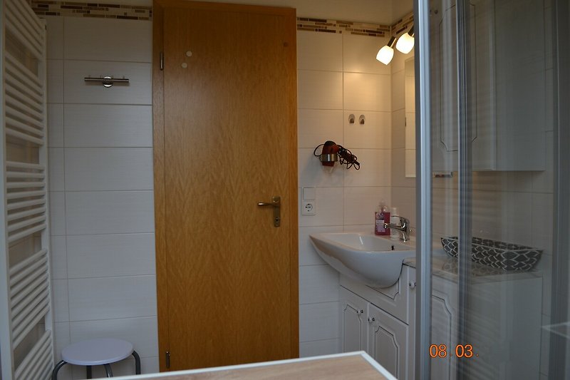 Schönes Badezimmer mit Holzboden und Spiegel.