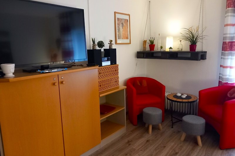Wohnzimmer mit großem Flachbildschirm mit Wlan-Funktion und gemütlicher Sitzecke