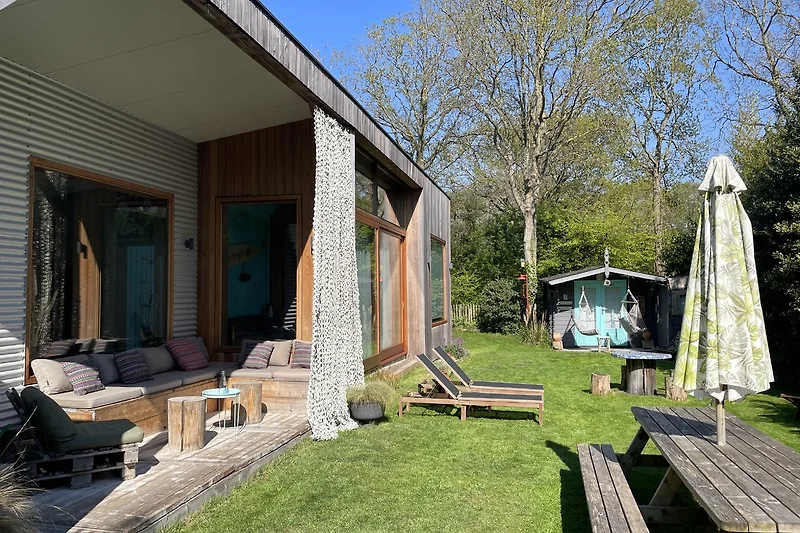 Grüne Gartenanlage mit Rasen und kleinen Gebäuden