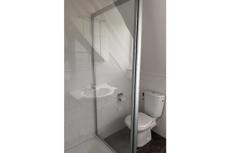 Modernes Badezimmer mit Spiegel, Armaturen und Fliesen.