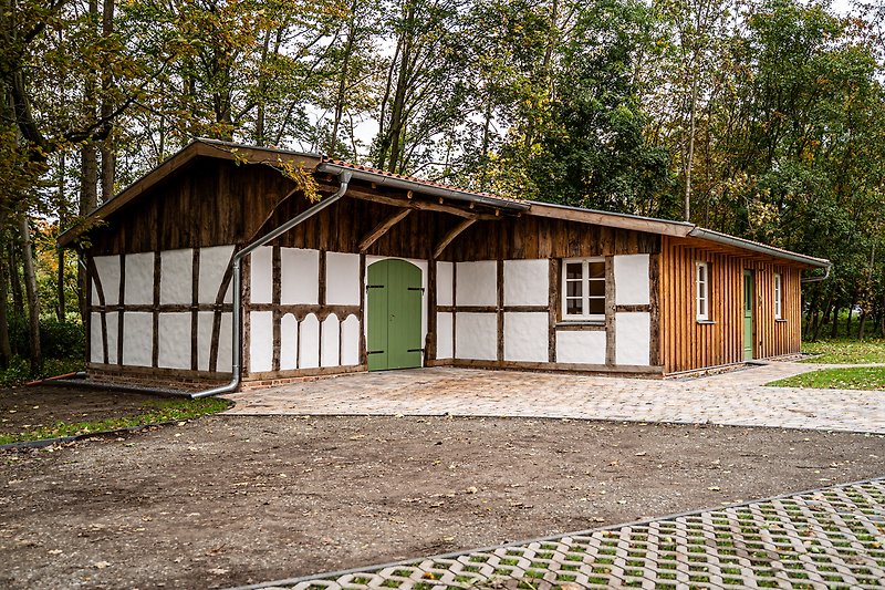 Gemütliches Ferienhaus mit grünem Garten, Holzfassade und malerischer Landschaft.