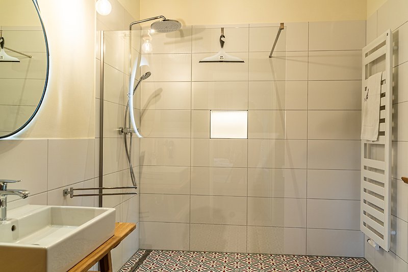 Stilvolles Badezimmer mit modernen Armaturen und elegantem Spiegel.