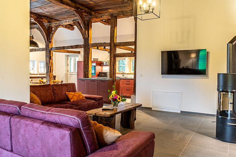 Gemütliches Wohnzimmer mit bequemer Couch, stilvollem Mobiliar und warmem Holzdekor.