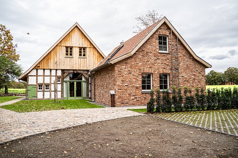 Stilvolles Haus mit schönem Garten, Holzfassade und gepflegtem Vorgarten.