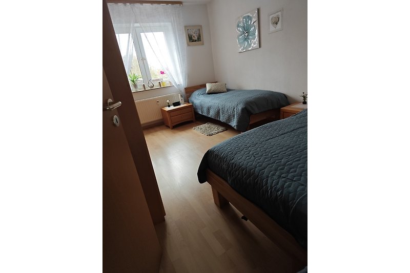 Schlafzimmer 1 mit Holzmöbeln und gemütlichen Einzelbetten 90x200 cm