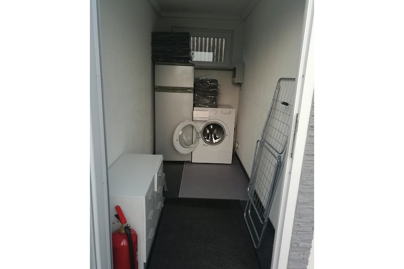 Nebenraum mit Waschmaschine und großem Kühlschrank