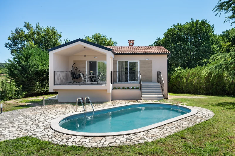 Villa mit Swimmingpool und gepflegtem Garten im Hinterhof.