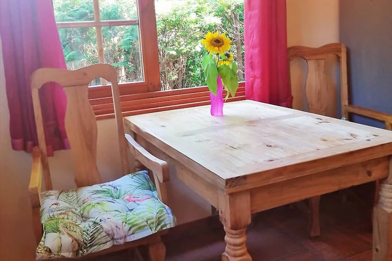 Einladendes Interieur mit Holzmöbeln und blumiger Dekoration.