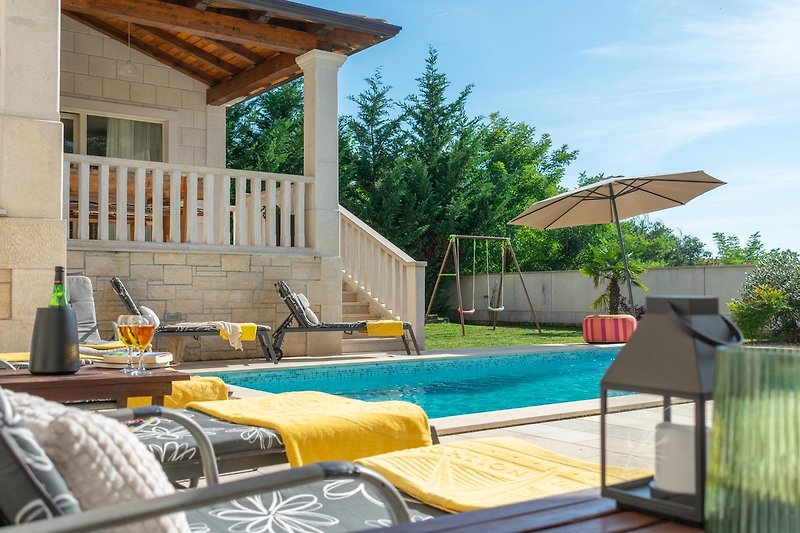 Relax by the pool in this outdoor paradise with comfortable furniture and a beautiful view.