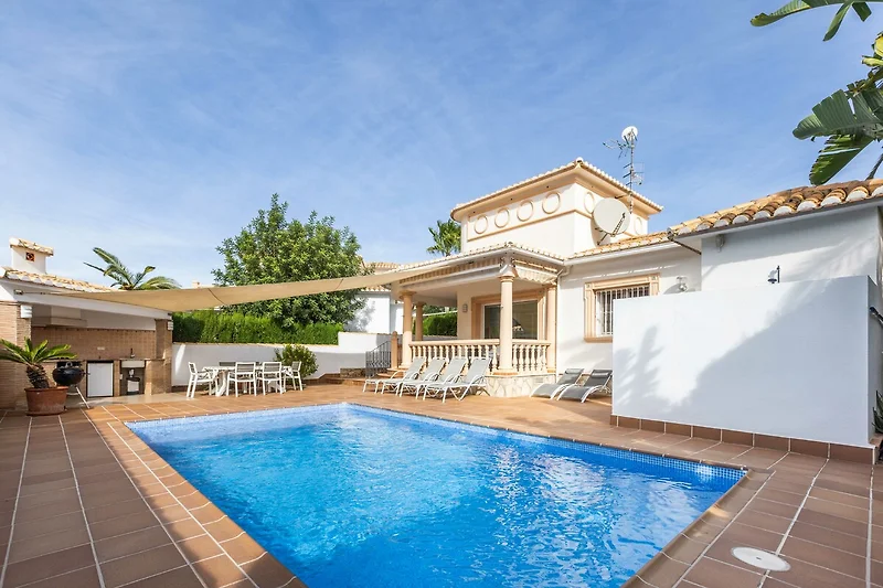 Exklusive Hacienda mit Pool, Palmen, Sonnenschirmen und Relax-Liegen.