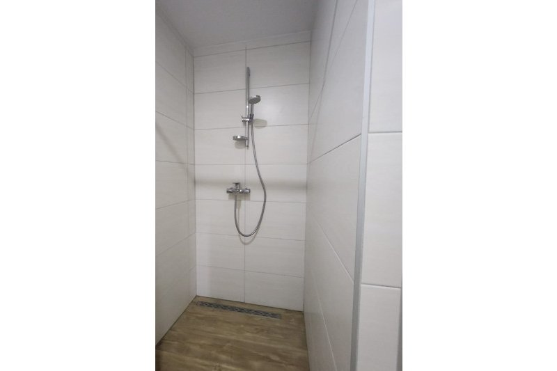 Schönes Badezimmer mit moderner Dusche und Glasduschkopf.
