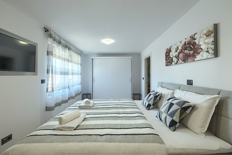 Elegantes Schlafzimmer mit symmetrischem Bett und Lampen.