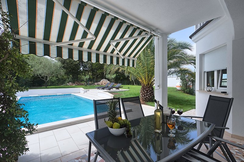 Private villa with pool, garden, and outdoor furniture.