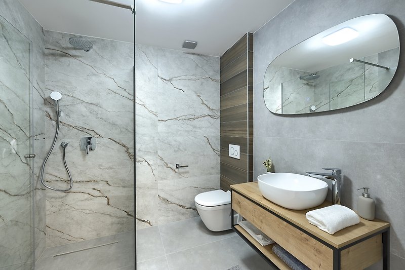 Modernes Badezimmer mit Spiegel, Armatur und Keramik.