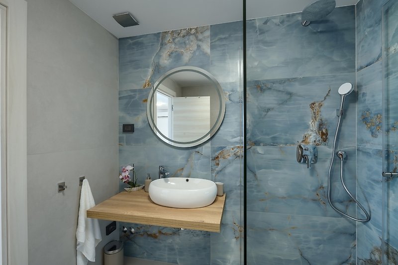 Modernes Badezimmer mit Holz- und Keramikelementen.