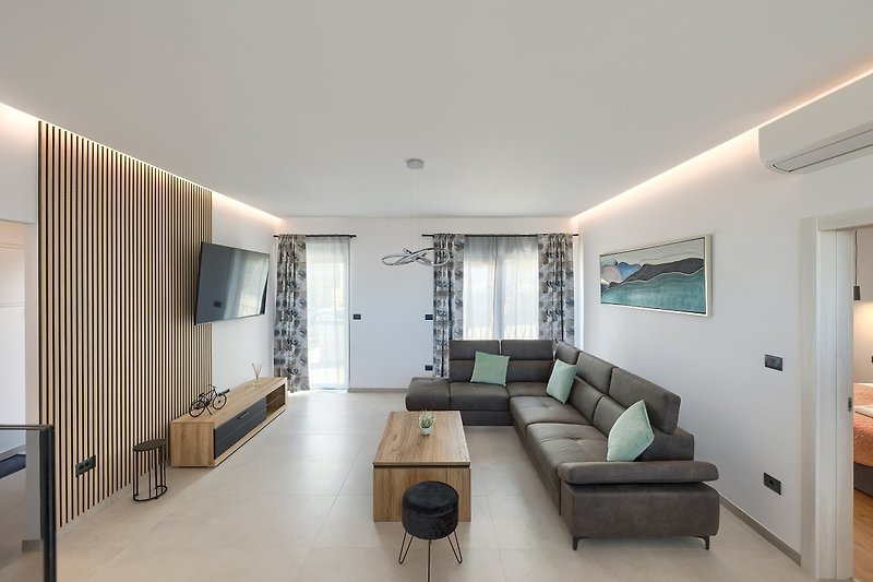 Wohnzimmer mit Sofa, Tisch und TV in modernem Stil.