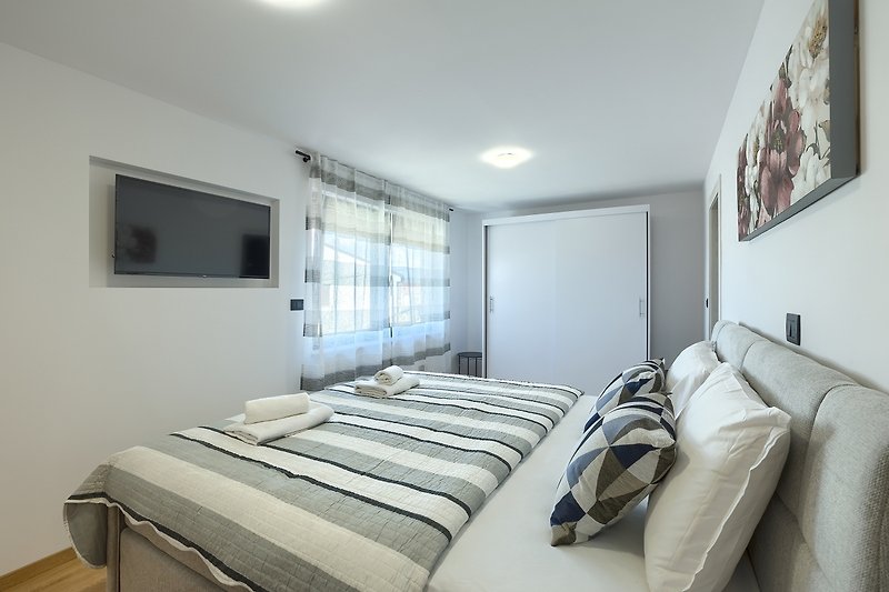 Elegantes Schlafzimmer mit gemütlichem Bett und stilvoller Einrichtung.