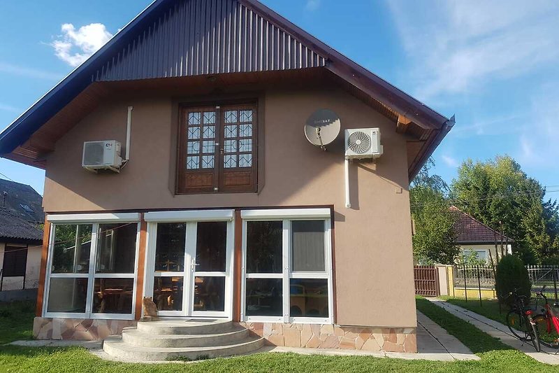 Großes Haus mit Garten, Einfahrt und Veranda in ruhiger Wohngegend.