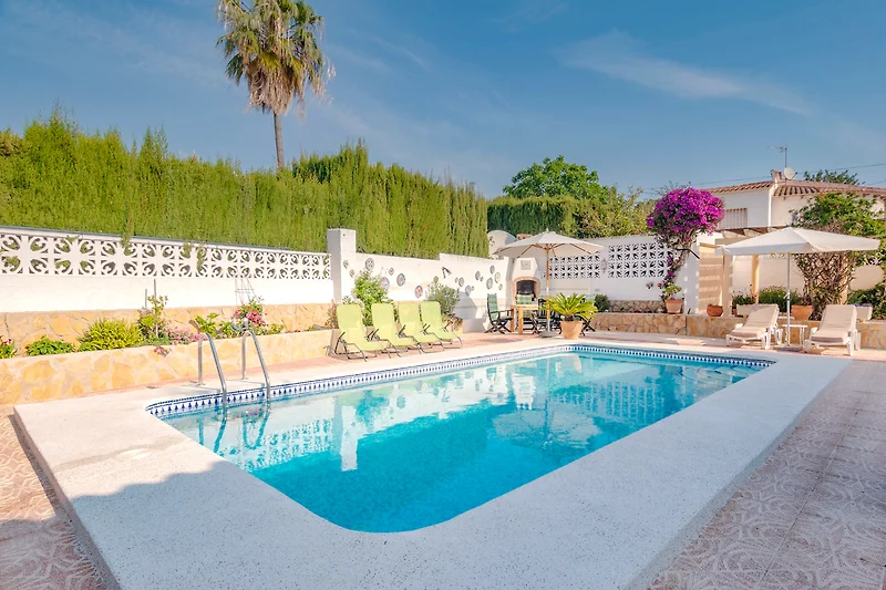 Erfrischender Pool, Palmen, Sonnenschirme und bequeme Liegestühle.