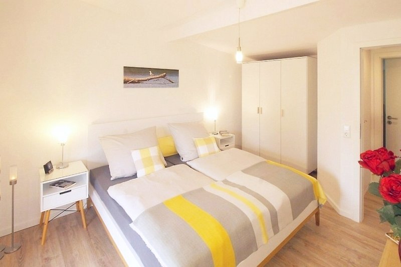Gemütliches Schlafzimmer mit bequemem Bett, stilvoller Beleuchtung und Holzboden.
