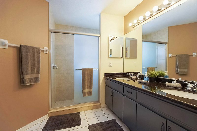 Gemütliches Badezimmer mit modernen Armaturen, Spiegel und Holzakzenten.