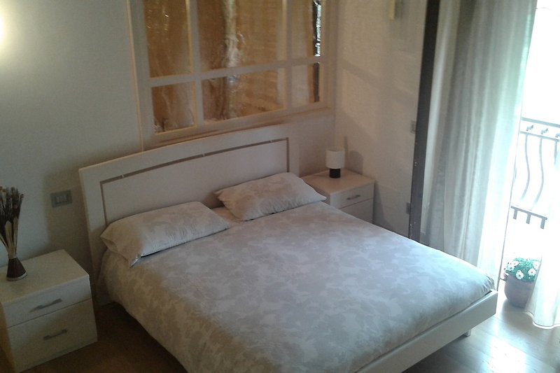 Schlafzimmer mit elegantem Bett und Holzboden.