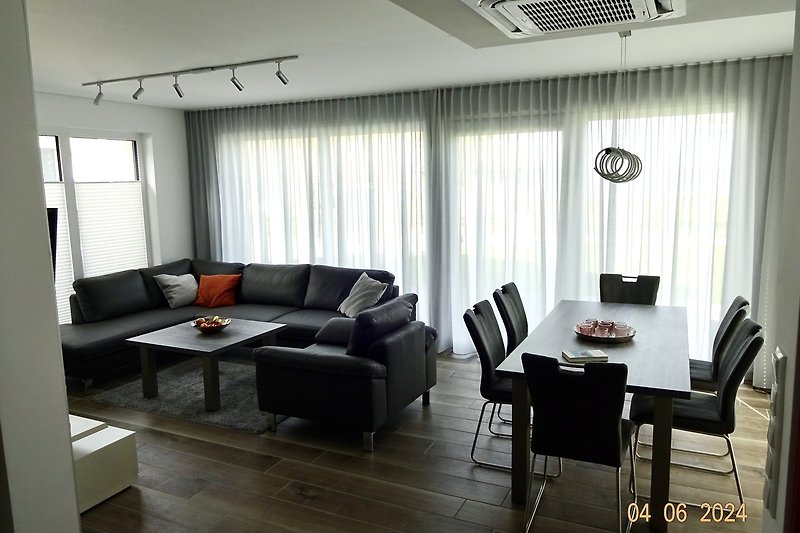 Stilvolles Wohnzimmer mit bequemen Möbeln und moderner Einrichtung mit Blick auf den See