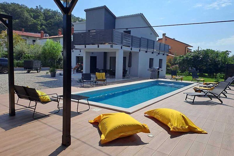 Schwimmbad und Außenmöbel in einer Ferienwohnung mit Blick auf die Stadt.