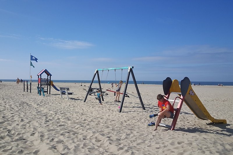 Op het strand is een speeltuintje, vlakbij het strandhuisje