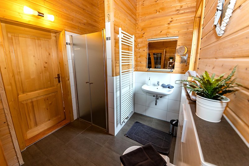 Ein stilvolles Badezimmer mit Holzboden und modernem Waschbecken.