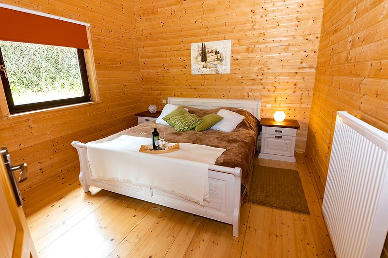 Ein stilvolles Schlafzimmer mit Holzboden und gemütlichem Bett.