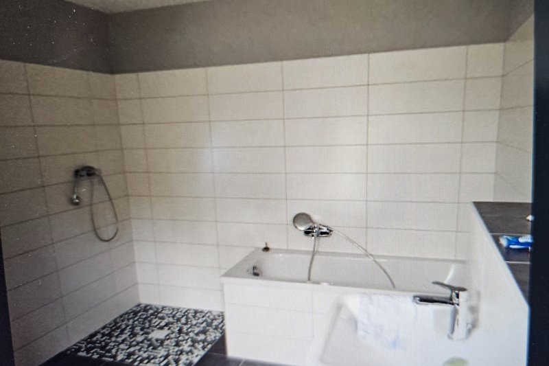 Modernes Badezimmer mit Glasdusche und Keramikwaschbecken.